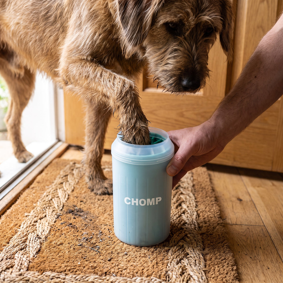 A muddy paw in the CHOMP Paw Washer Cup